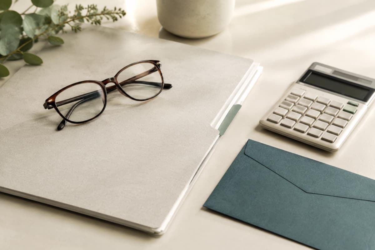 Retirement documents, glasses and a calculator on a desk