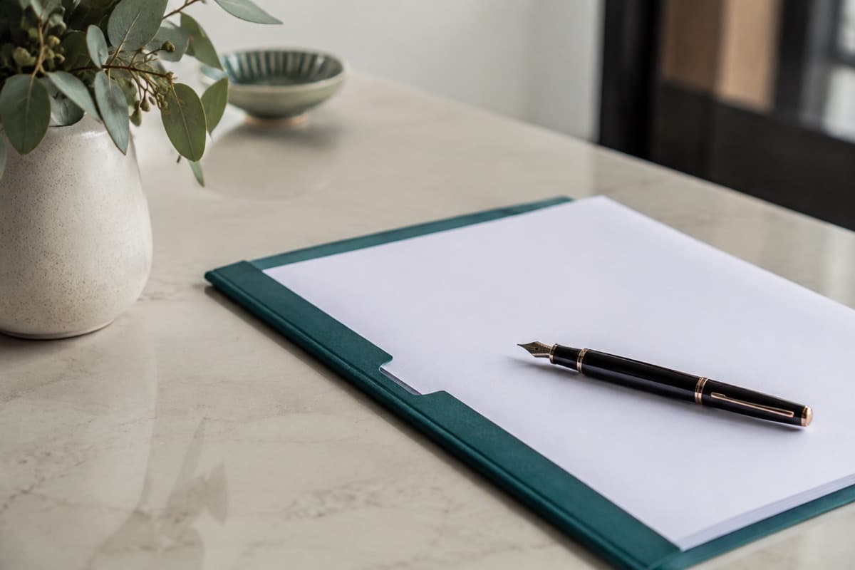 A Will document and fountain pen in a teal folder